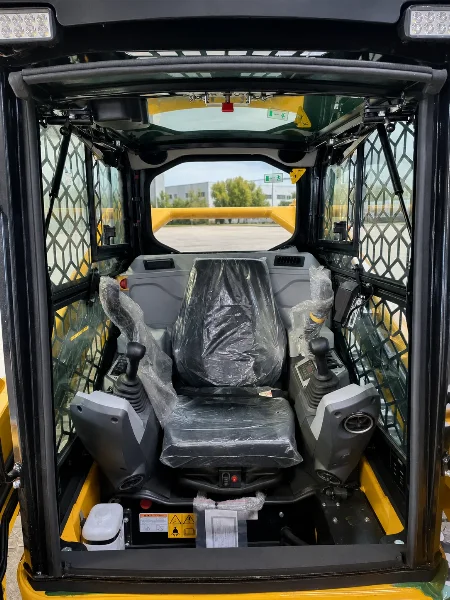 Интериор на кабината на CDM315T със защитена седалка, управление и предпазна решетка.