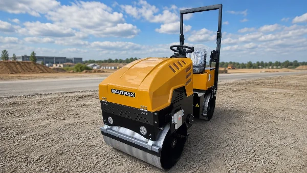 Bautrax DR10 отпред-вдясно върху подготвена пътна основа с видим контакт на стоманения барабан.