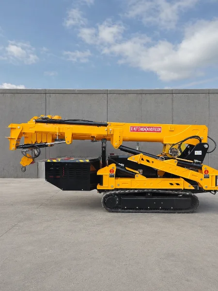 Спайдър кран BAUTRAX SPC50 в прибрано транспортно положение на гумени вериги, страничен изглед на фона на синьо небе