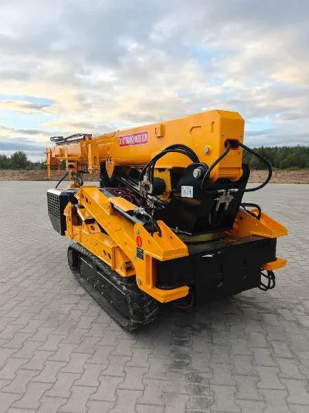 Спайдър кран BAUTRAX SPC50, заден ъглов изглед на гумени вериги по здрач